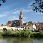 Eine malerische Steinbrücke überspannt den Fluss vor der Altstadt von Regensburg.
