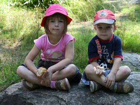 Zwei Kinder sitzen auf einem Stein